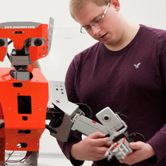 student examining a robot