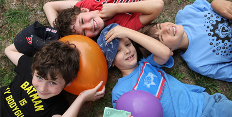 4 boys lying on the grass